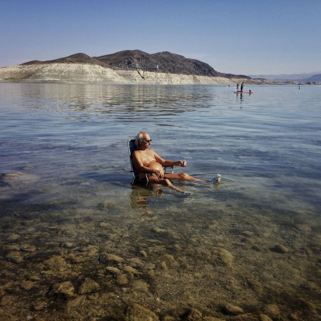 Roger Dell relaxes in the water at Lake Mead’s Boulder Beach, June 20, 2015. A high-water mark or “bathtub ring” is visible on the shoreline; Lake Mead is down over 150 vertical feet.