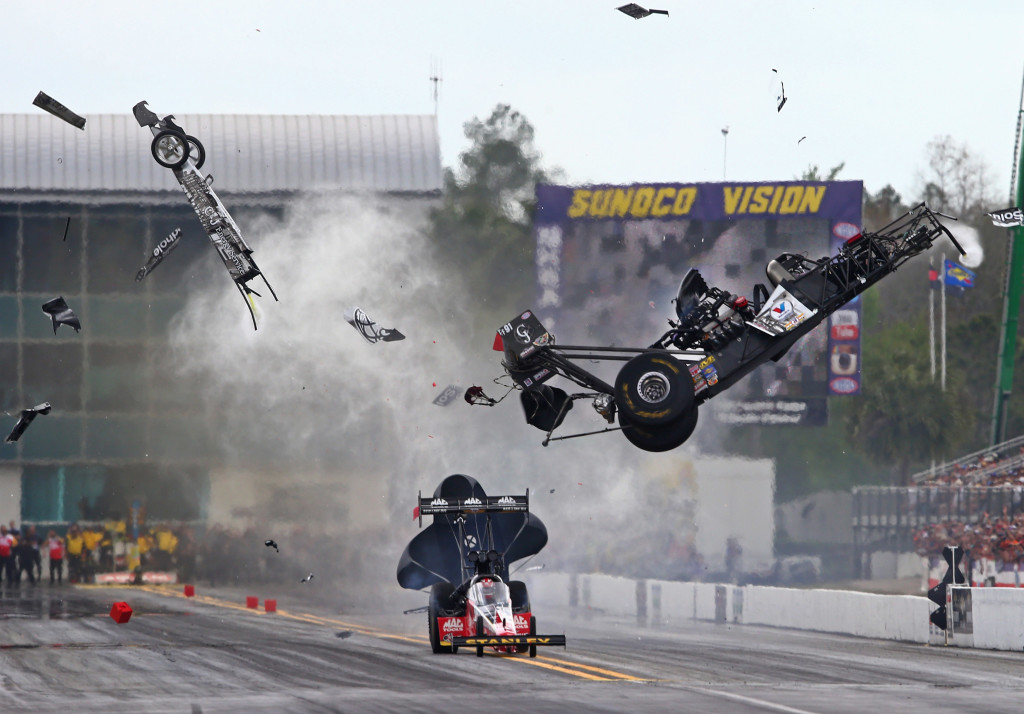Mar 14, 2015; Gainesville, FL, USA; NHRA top fuel dragster driver Larry Dixon (right) crashes and goes airborne alongside Doug Kalitta after his car broke in half during qualifying for the Gatornationals at Auto Plus Raceway at Gainesville. Dixon walked away from the incident. Mandatory Credit: Mark J. Rebilas-